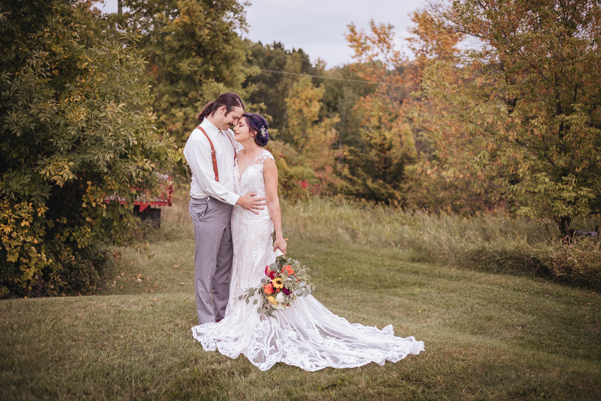 bride and groom at their sustainable wedding surrounded by nature in the fall