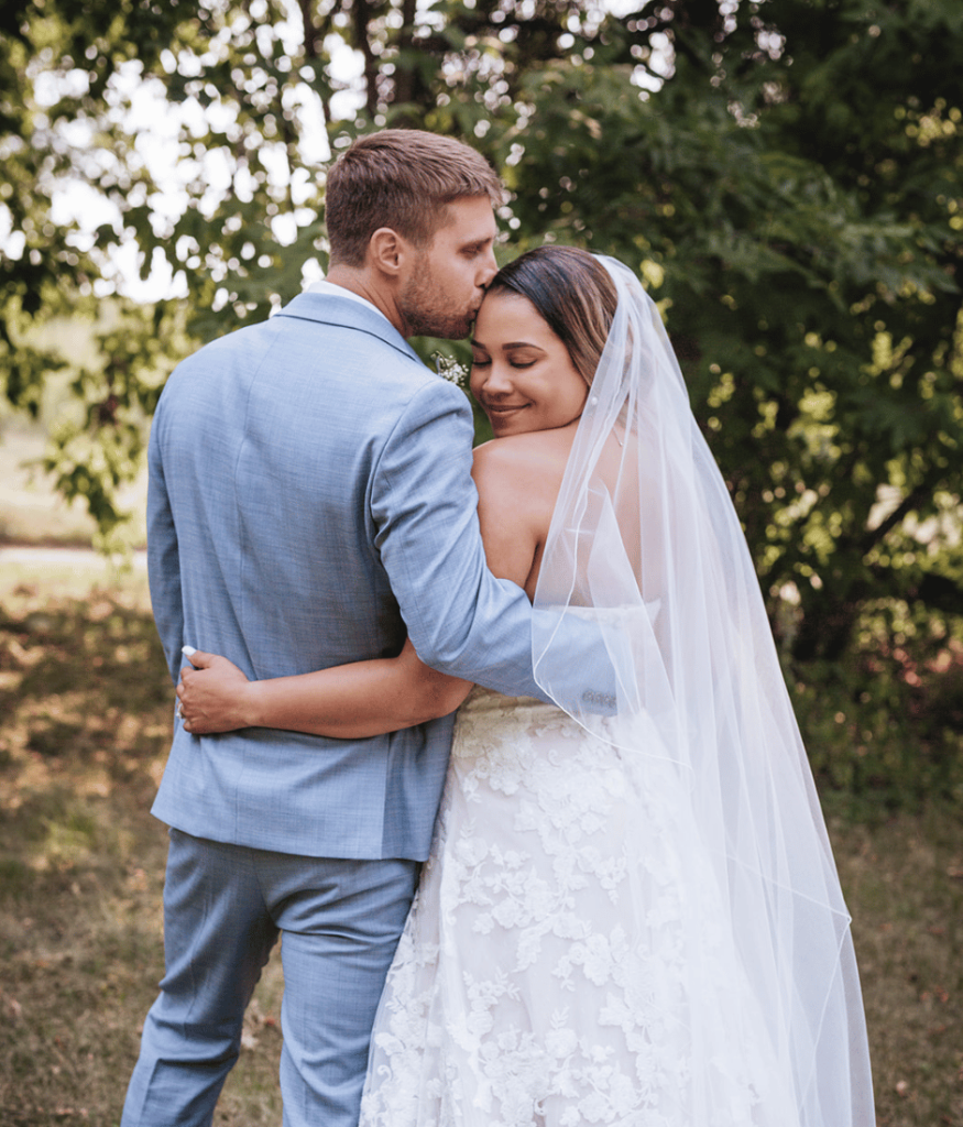 When thinking how to plan a elopment this post dives into helpful information so you can look like this couple standing embraced after their elopement ceremony. Couple standing together in wedding attire. 