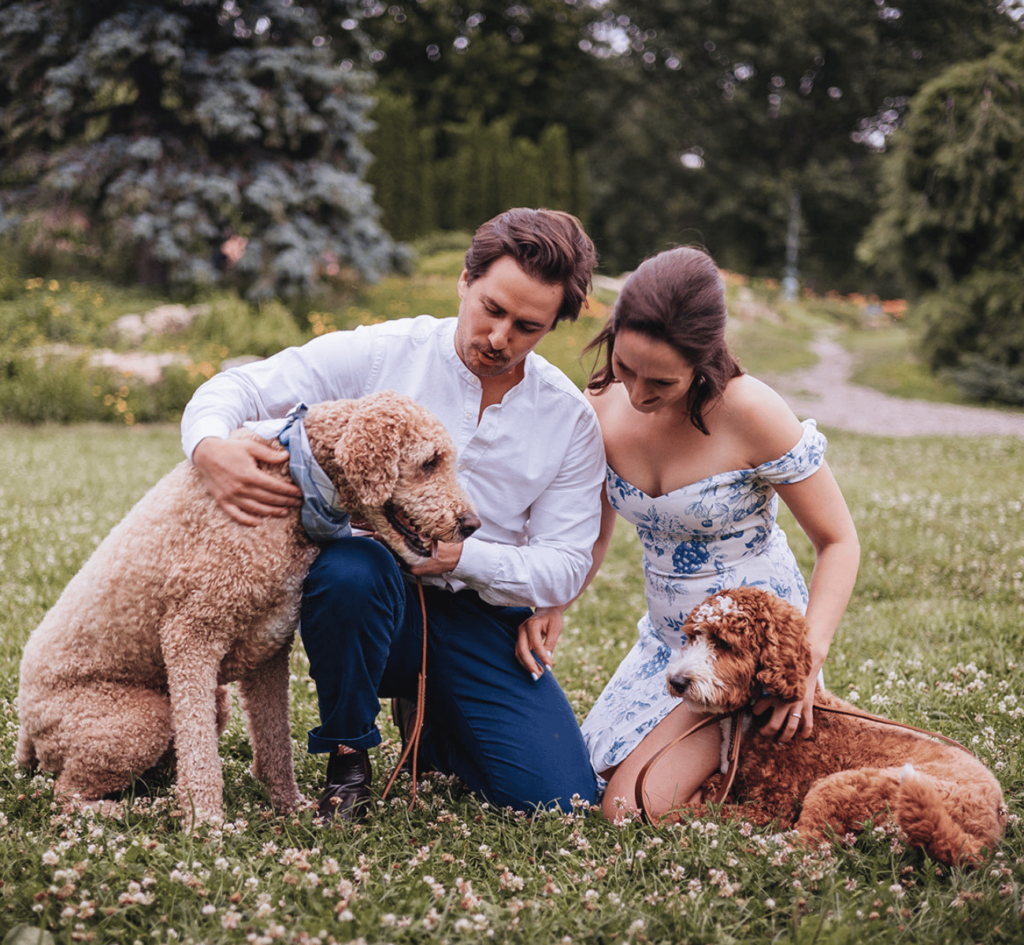 A couple during their engagement photos brought their 2 dogs to the session. The couple and dogs are all snuggling and smiling! 