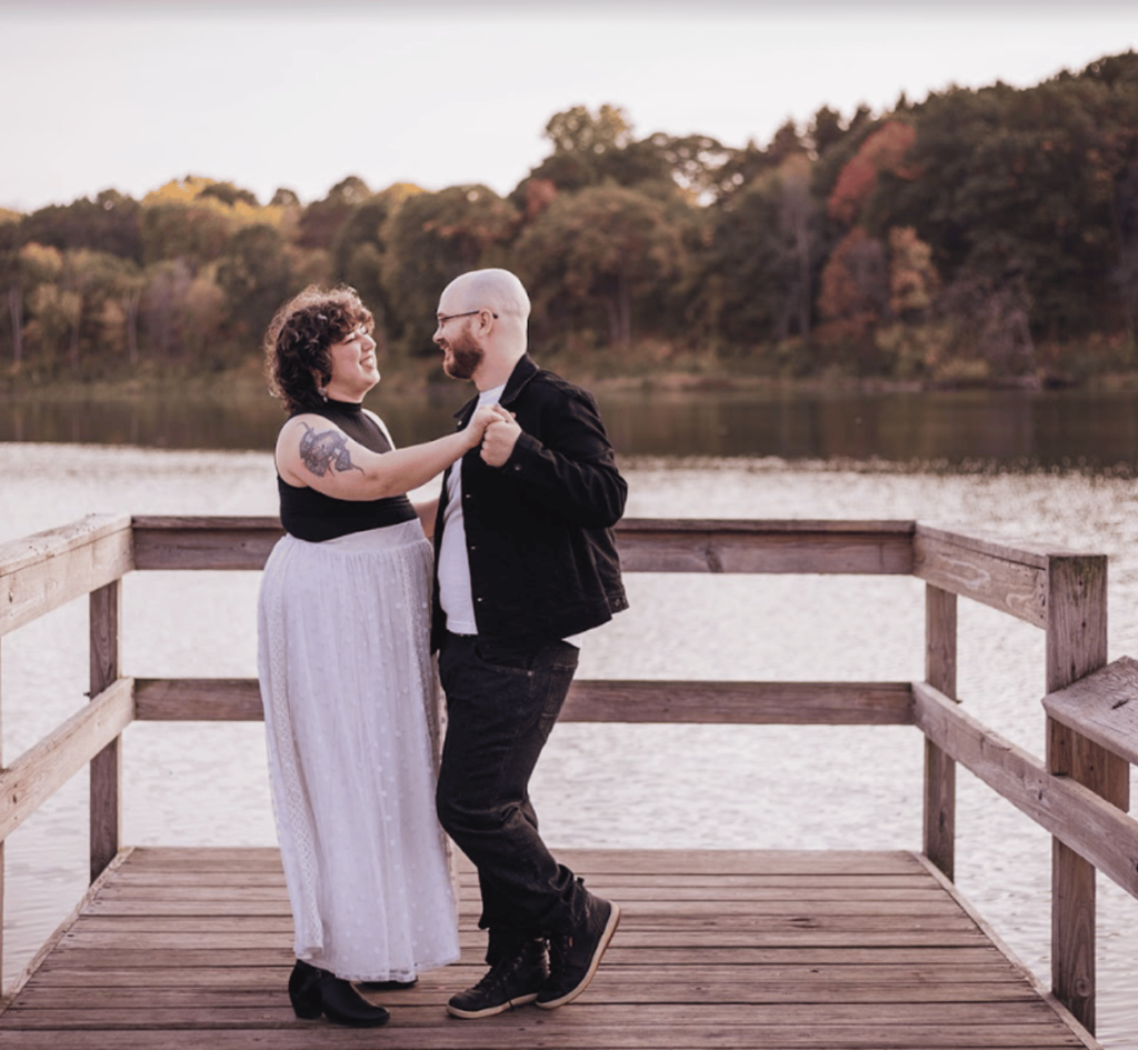 Image of a couple dancing for their wedding photography. They are standing on a dock above water.