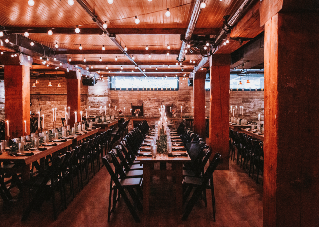 Image of Aster Cafe being empy and set up for a wedding with long rectanlge tables with candles and table settings. This is one of our Minneapolis Wedding Venues that were showcasing. 