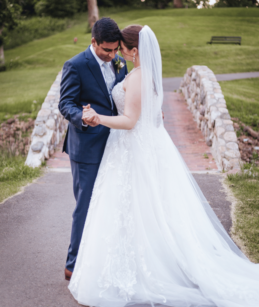 Image of a couple on their wedding day dancing on a path showing the true love between them. Before booking a wedding photographer make sure you do your research for someone who can capture these special moments. 