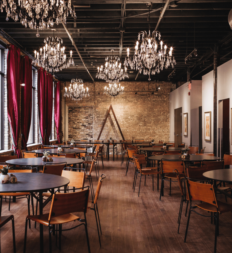 Image of Watson block, one of my recommended Minneapolis Wedding Venues. This image is a empty room that is table sand chairs with elegant chandeliers. 