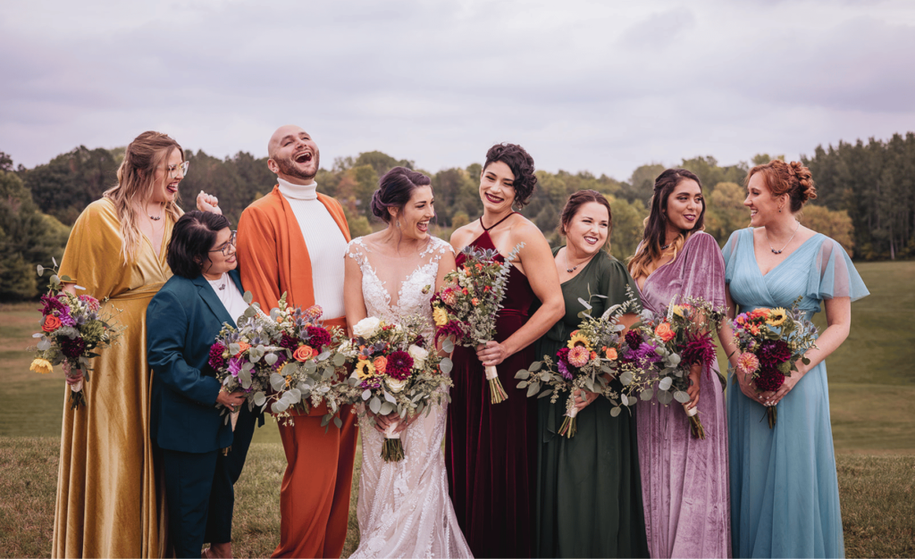 Image of mixed wedding party, all individuals are smiling and laughing and enjoying themselves during wedding party pictures. 