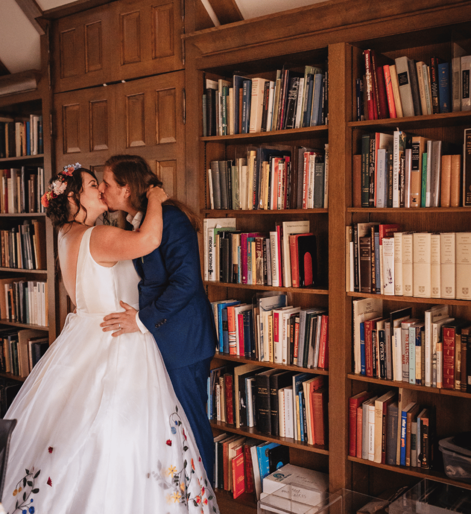 Image of a couple kissing in the library at the Bakken Museum. 