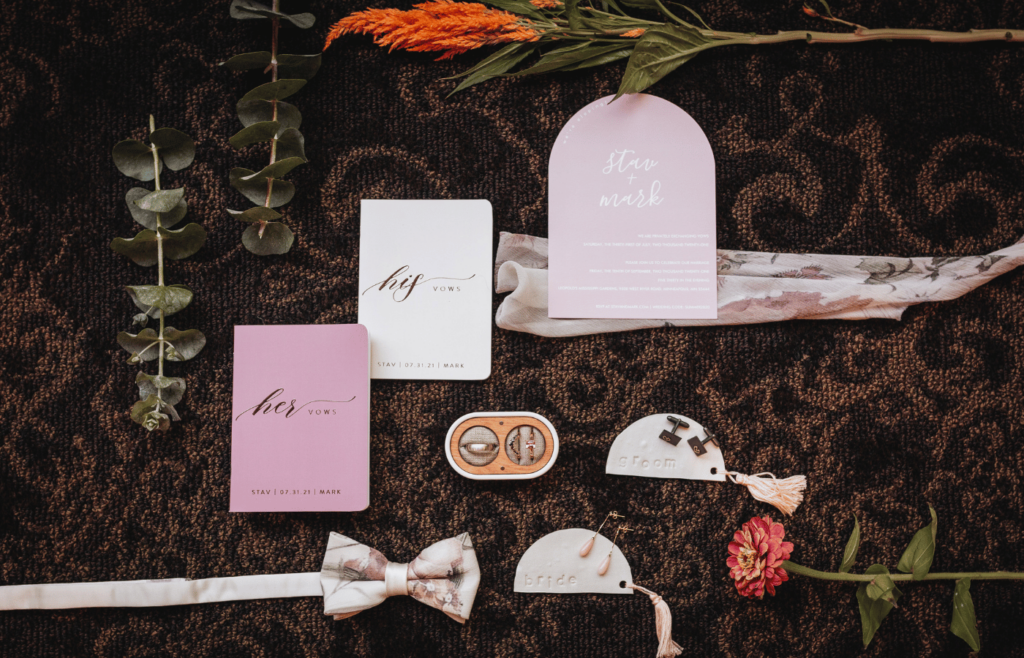 Image of his and her detail items such as earrings, cuff links, vow cards and wedding invite. 