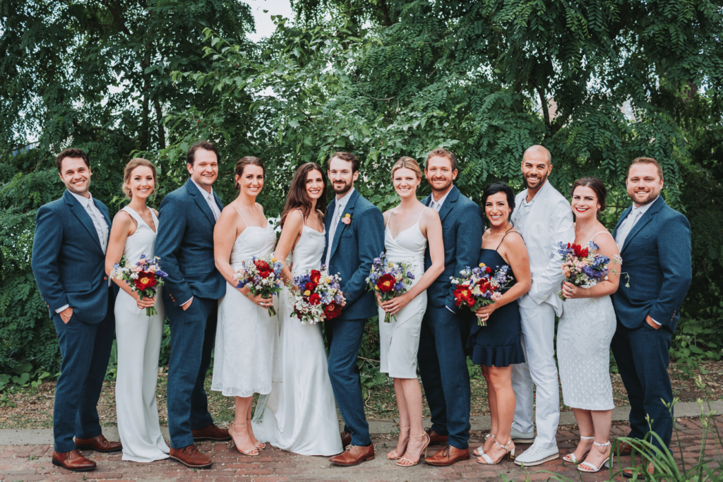 Image of a couples wedding party with the bride and groom celebrating on their wedding day. This image is showing how to start planning a wedding with thinking about your wedding party.