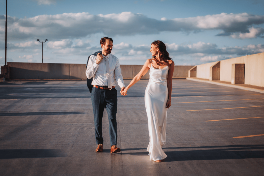 Image of a bride and groom walking alone together outside in the setting sun. 