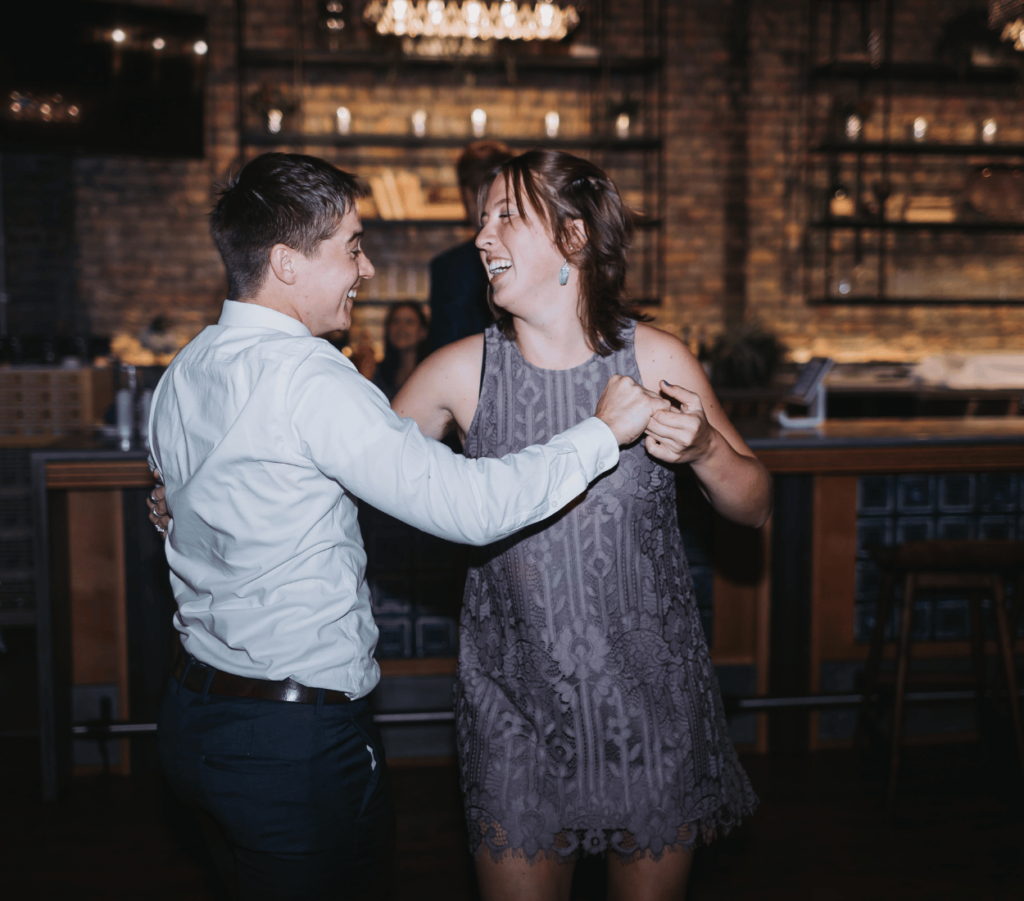 Image of wedding attendee's dancing during wedding reception. Showing how what to do with wedding photos with using reception photos in a digital or physical photo album. 