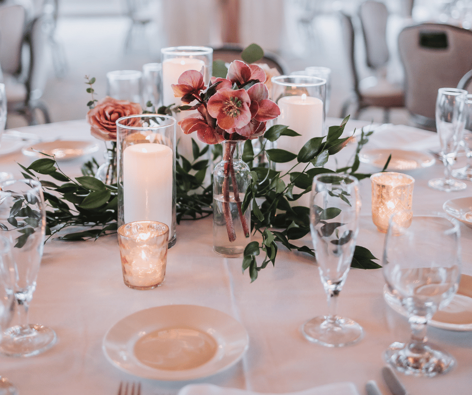 Image of centerpieces on tables at wedding reception. Helping with learning more about what to look for in a wedding planner. 
